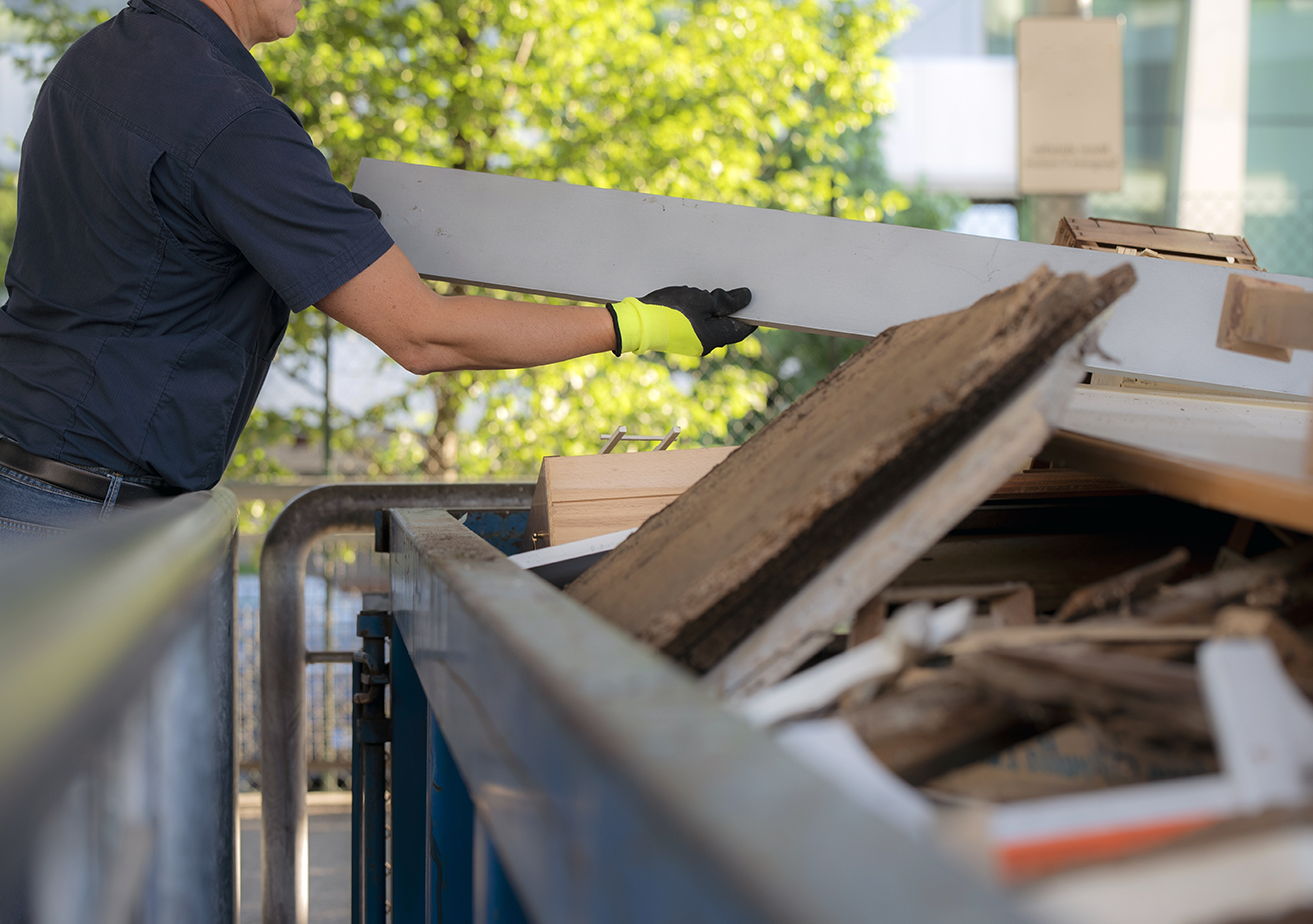 A separate collection employee distributes the various waste in special recycling bins. Worker at work in a recycling center.